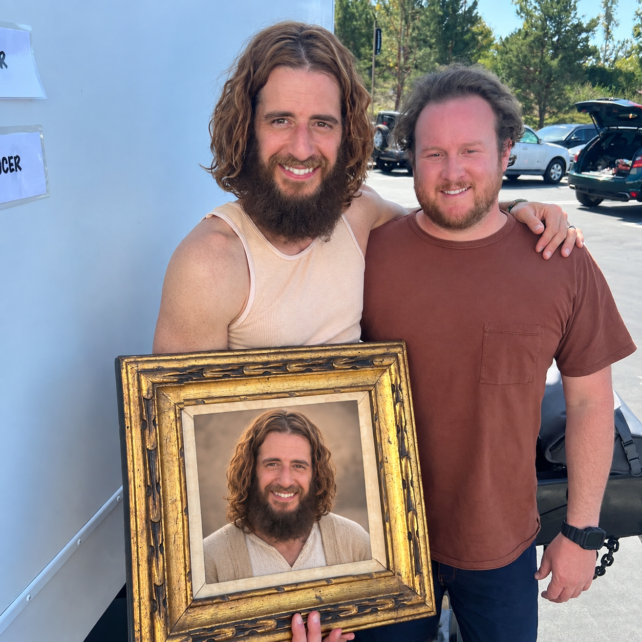 Jonathan standing beside a customer holding a personalized framed portrait of Jonathan