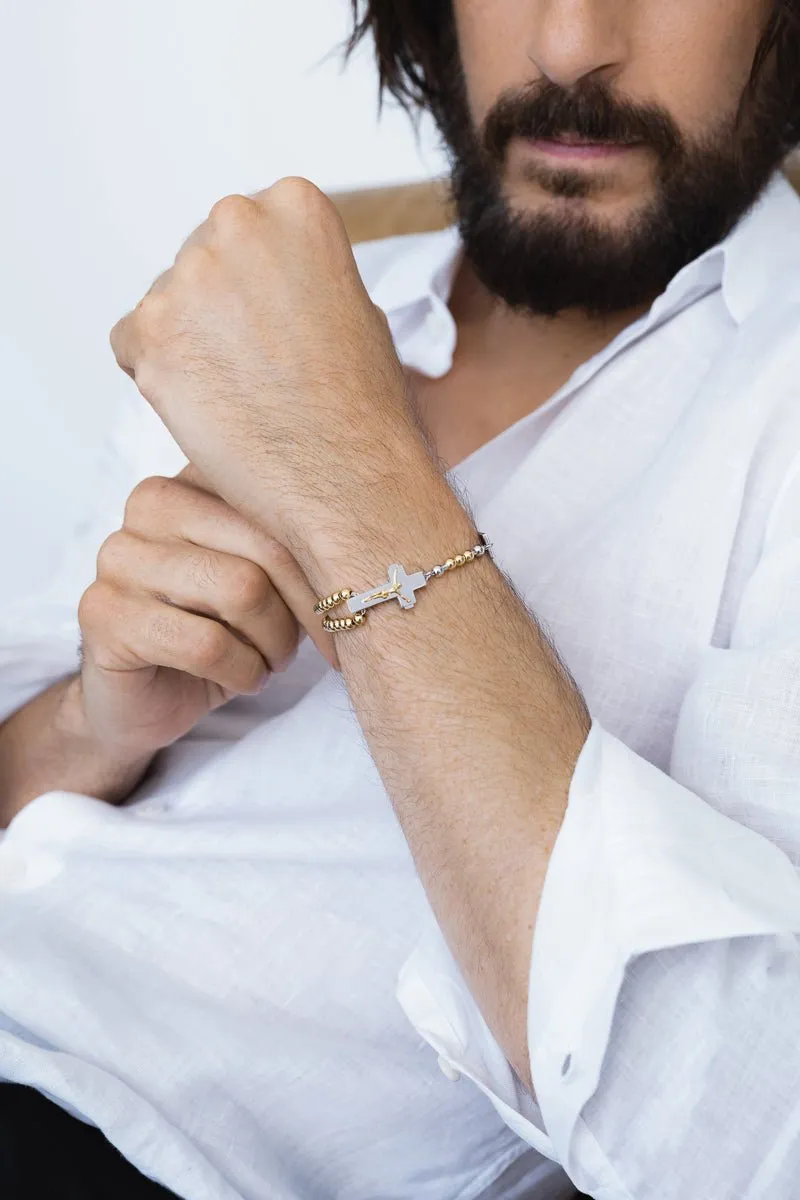 Close-up of a gold-tone rosary bracelet worn by Jonathan Roumie
